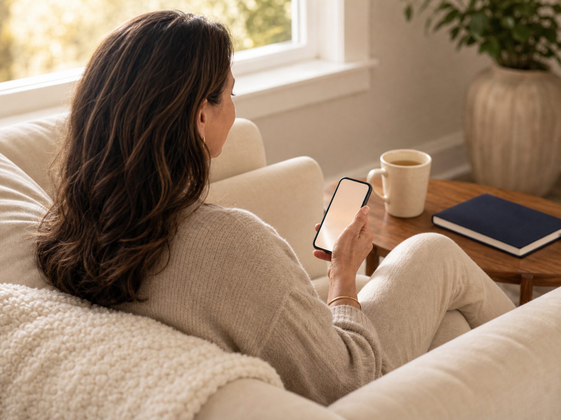 A woman at home checking in on her phone during a calm moment